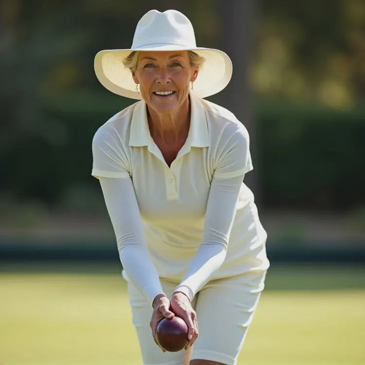 Bowler wearing white arm sleeves while holding a bowl on the green.